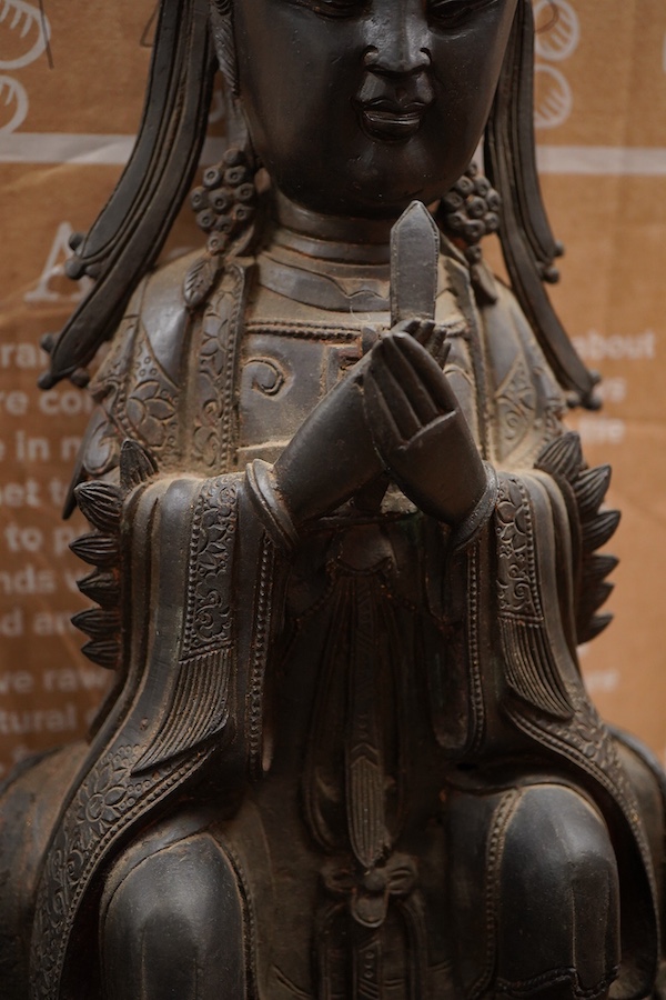 A Chinese late Ming bronze seated figure of Xi Wangmu, early 17th century (on stand). 34.5cm high not including stand.